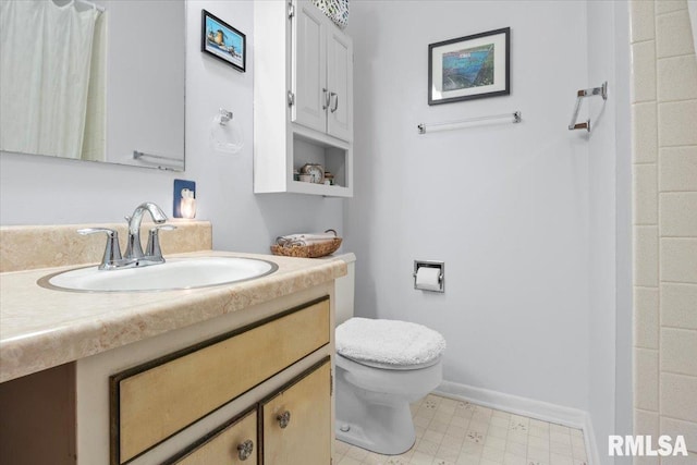 full bath featuring vanity, baseboards, tile patterned floors, and toilet
