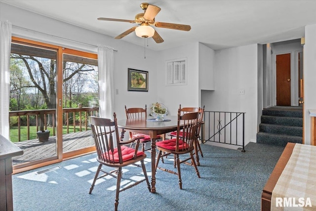 carpeted dining area with a ceiling fan and visible vents