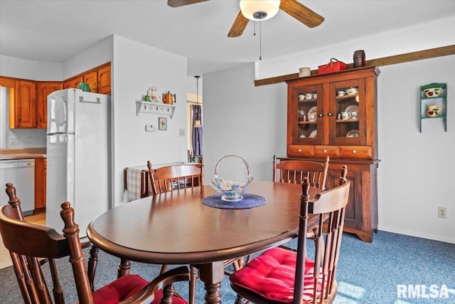 dining area featuring a ceiling fan and light colored carpet