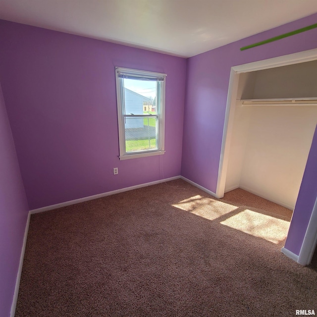unfurnished bedroom featuring carpet floors, baseboards, and a closet