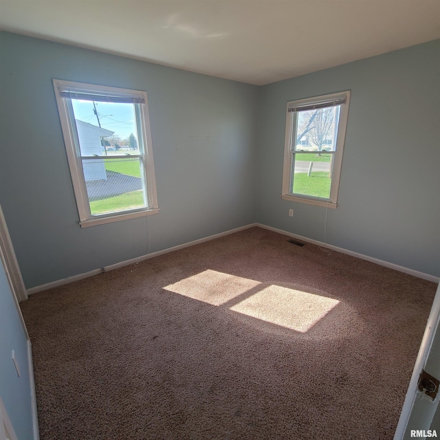 carpeted empty room with baseboards and visible vents