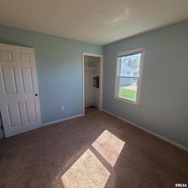 unfurnished bedroom with a closet, carpet flooring, and baseboards