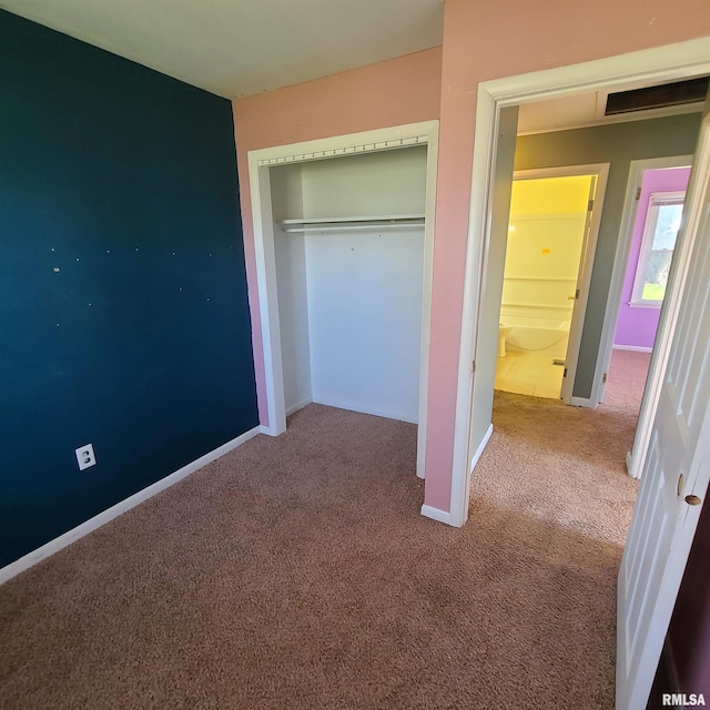 unfurnished bedroom featuring baseboards, carpet, and a closet