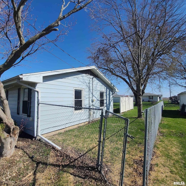 view of property exterior featuring a lawn, fence, and a gate