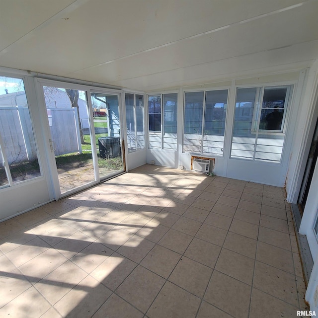 unfurnished sunroom with a wall mounted air conditioner