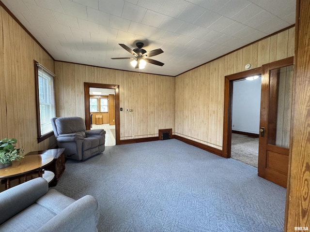 living area featuring ornamental molding, carpet, and wood walls