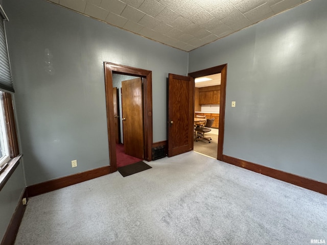 carpeted empty room featuring baseboards