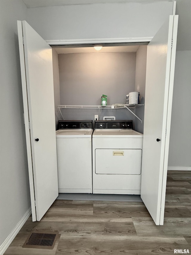 washroom with visible vents, laundry area, wood finished floors, and washer and dryer