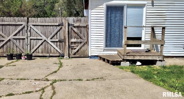 exterior space with fence, a wooden deck, and a gate