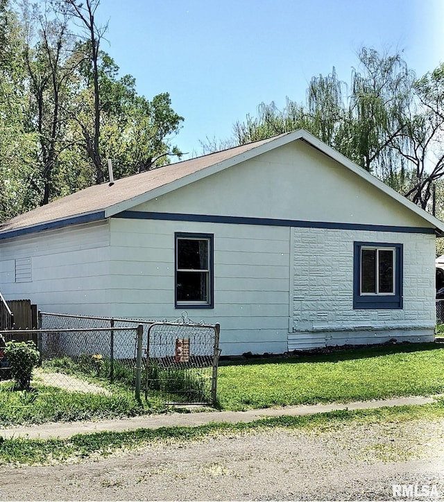 view of property exterior featuring fence and a lawn