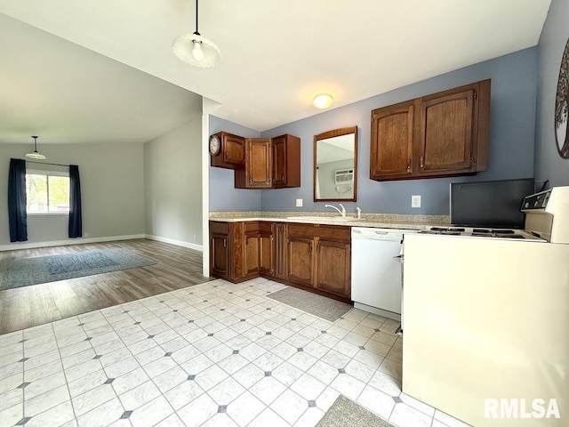 kitchen with pendant lighting, white appliances, baseboards, light countertops, and a sink