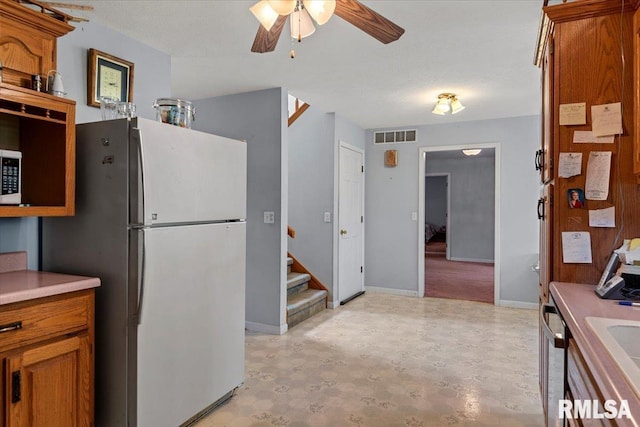 3300 Winch Rd, Springfield, IL 62707 - kitchen with freestanding refrigerator, brown cabinets, a ceiling fan, and light flooring