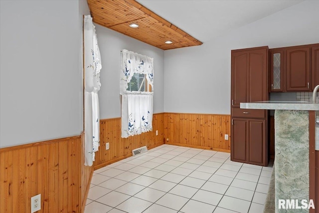 unfurnished dining area featuring visible vents, wood walls, wainscoting, light tile patterned flooring, and recessed lighting