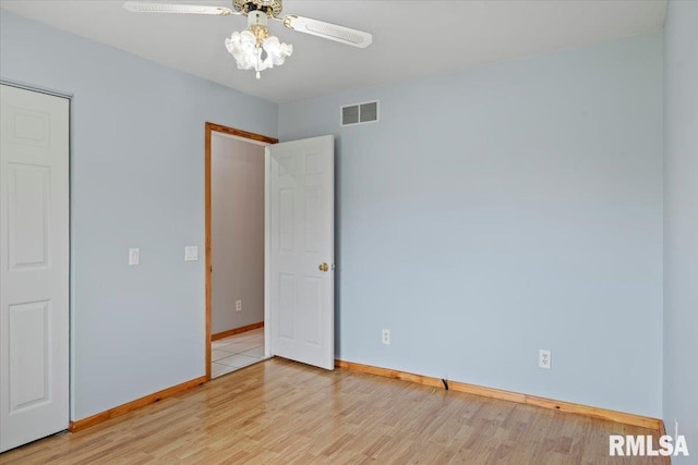 unfurnished bedroom with visible vents, a ceiling fan, baseboards, and light wood-type flooring