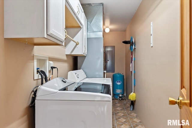 washroom with stone finish floor, electric panel, washing machine and dryer, and cabinet space