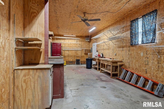 misc room with concrete floors, ceiling fan, and a workshop area