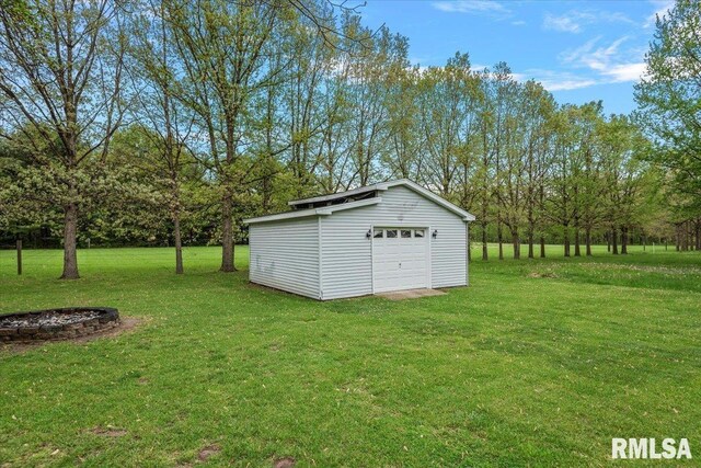 view of yard featuring a garage and an outbuilding