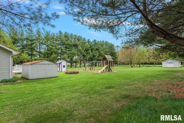 view of yard with a playground, a storage unit, and an outbuilding