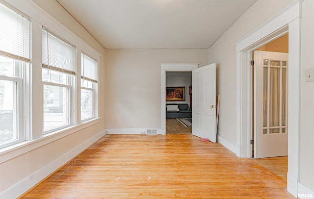 unfurnished room with baseboards, visible vents, and light wood-style floors