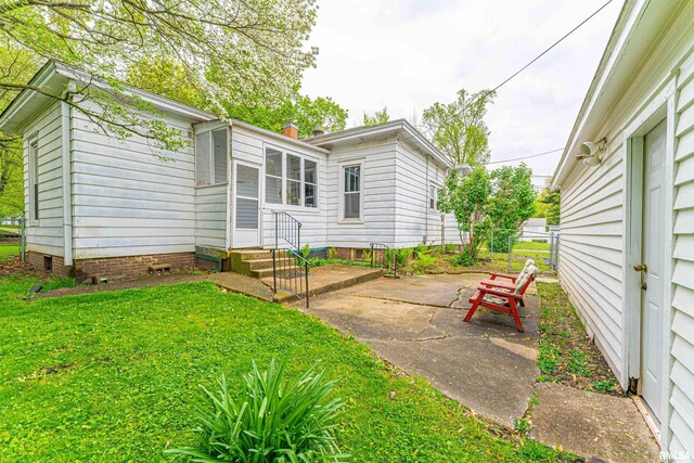 rear view of property with fence, a chimney, a patio area, entry steps, and a yard