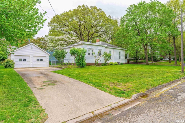 view of front of property featuring a front lawn, an outbuilding, a chimney, and a detached garage