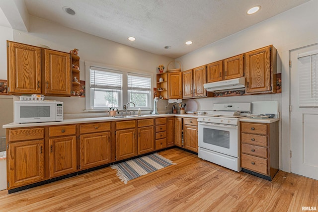 kitchen with open shelves, brown cabinets, a sink, under cabinet range hood, and white appliances