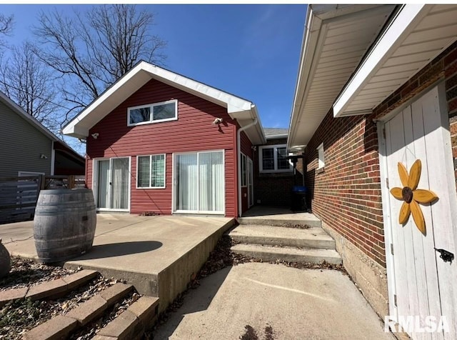 rear view of property with a patio and brick siding