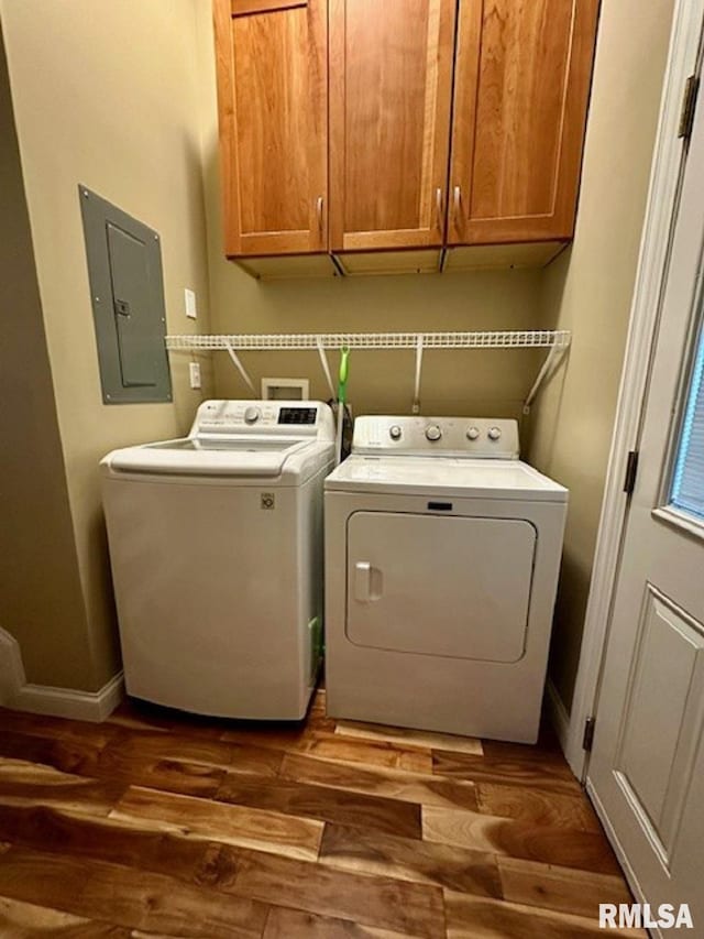 washroom with washing machine and clothes dryer, cabinet space, dark wood finished floors, baseboards, and electric panel