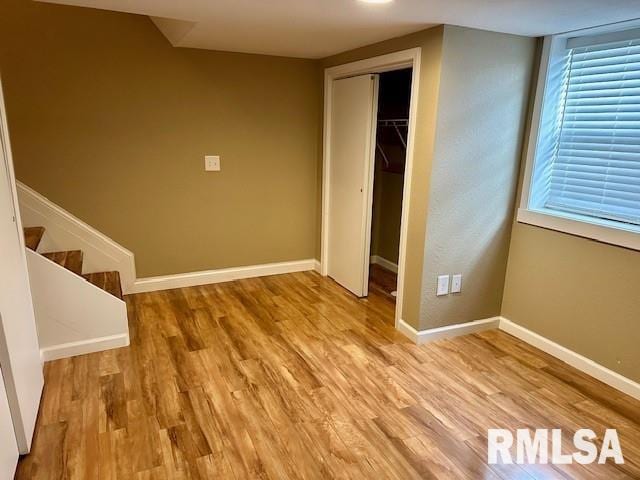 unfurnished bedroom featuring baseboards, a closet, and wood finished floors