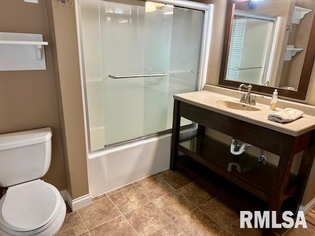full bathroom with vanity, enclosed tub / shower combo, and toilet