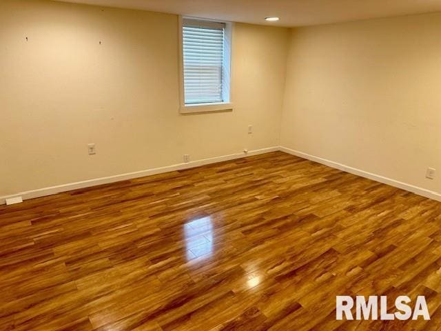 empty room featuring baseboards and dark wood-style floors
