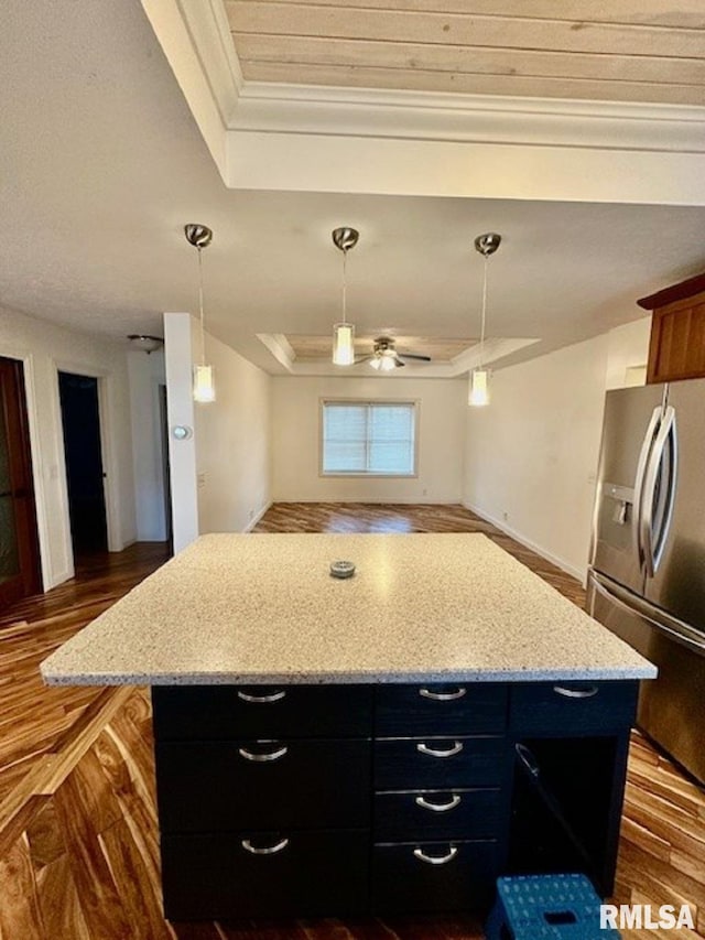 kitchen featuring dark wood-style flooring, a raised ceiling, dark cabinets, a kitchen island, and stainless steel refrigerator with ice dispenser