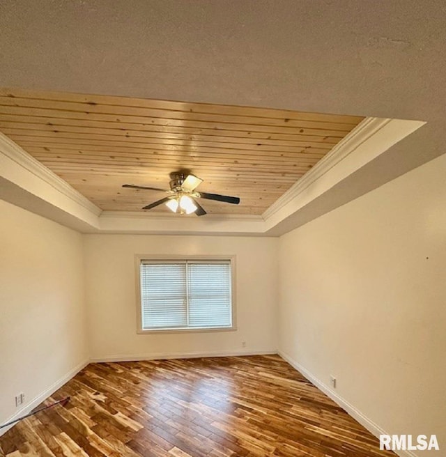 spare room featuring ornamental molding, a raised ceiling, a ceiling fan, and wood ceiling
