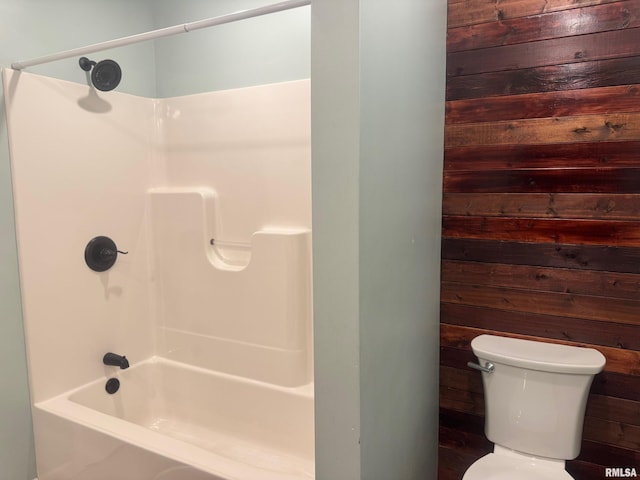 912 N Main St, Monroe City, MO 63456 - bathroom featuring wood walls, tub / shower combination, and toilet