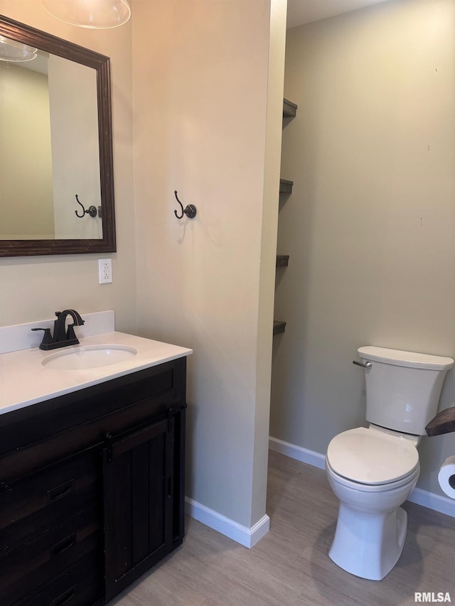 912 N Main St, Monroe City, MO 63456 - bathroom with vanity, baseboards, wood finished floors, and toilet