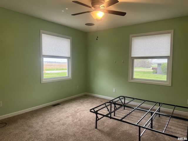 912 N Main St, Monroe City, MO 63456 - unfurnished bedroom featuring baseboards, a ceiling fan, visible vents, and light colored carpet