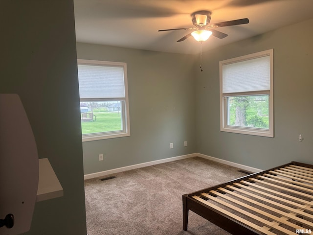 912 N Main St, Monroe City, MO 63456 - unfurnished bedroom with carpet floors, baseboards, visible vents, and ceiling fan