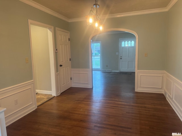 912 N Main St, Monroe City, MO 63456 - unfurnished dining area featuring crown molding, wainscoting, a decorative wall, arched walkways, and dark wood-type flooring