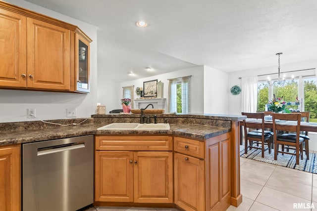 kitchen featuring stainless steel dishwasher, a sink, a peninsula, a chandelier, and plenty of natural light