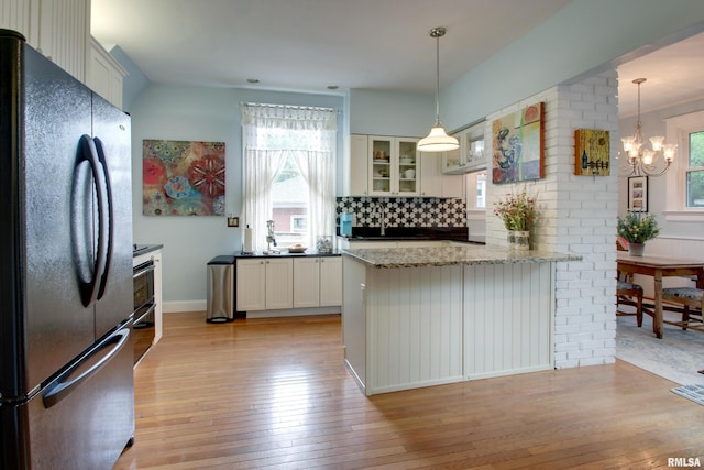 125 E Ave, Quincy, IL 62301 - kitchen with freestanding refrigerator, light wood-style flooring, a peninsula, glass insert cabinets, and decorative backsplash
