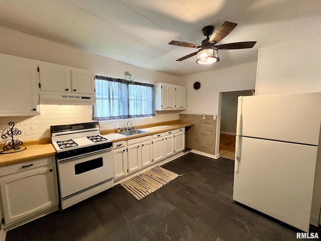 kitchen with white appliances, white cabinetry, under cabinet range hood, and a sink
