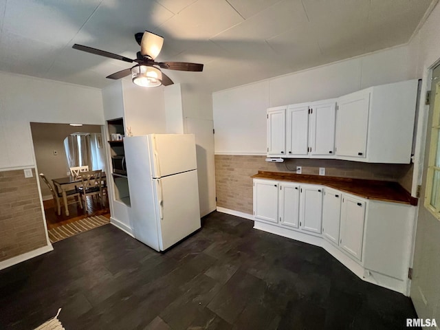 kitchen featuring freestanding refrigerator, dark wood-style flooring, baseboards, white cabinetry, and a ceiling fan