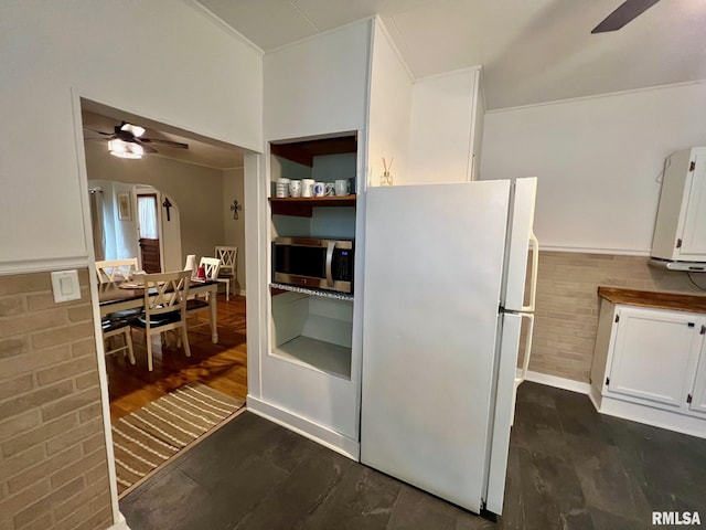 kitchen featuring freestanding refrigerator, ceiling fan, white cabinets, and stainless steel microwave