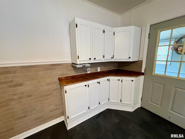 laundry area with dark wood-style flooring and a wainscoted wall
