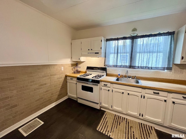 kitchen featuring visible vents, gas range gas stove, light countertops, under cabinet range hood, and a sink