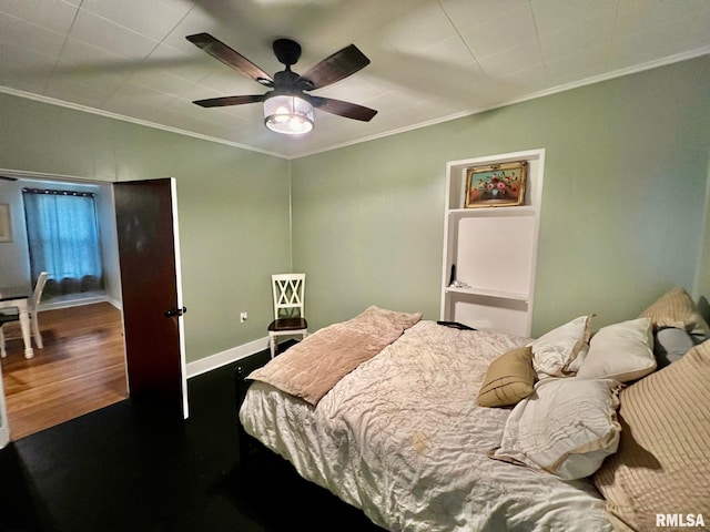 bedroom featuring crown molding, baseboards, ceiling fan, and wood finished floors