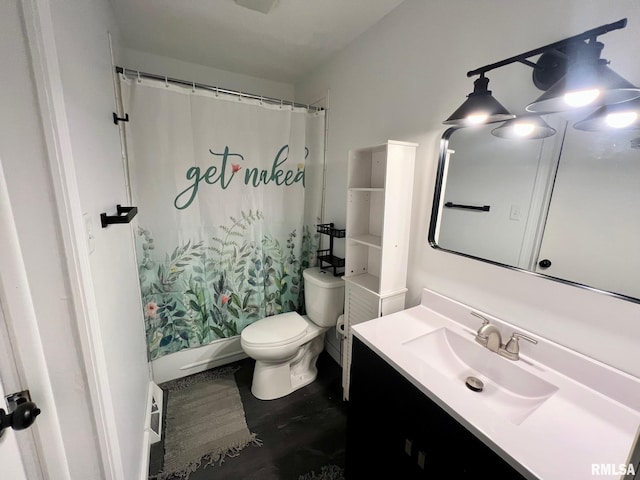 full bath with toilet, wood finished floors, and vanity