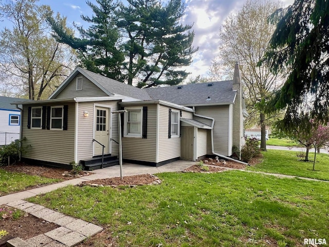 view of front of property with a shingled roof, a front lawn, and entry steps