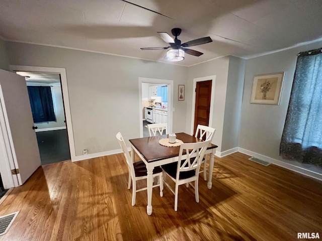 dining space with baseboards, ceiling fan, visible vents, and wood finished floors