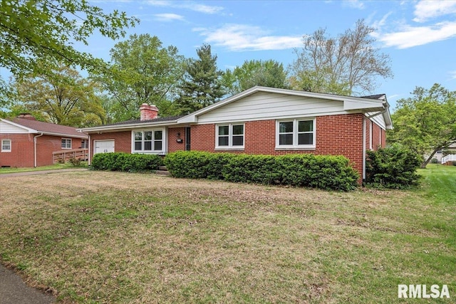 ranch-style house with brick siding, a chimney, a front lawn, and a garage
